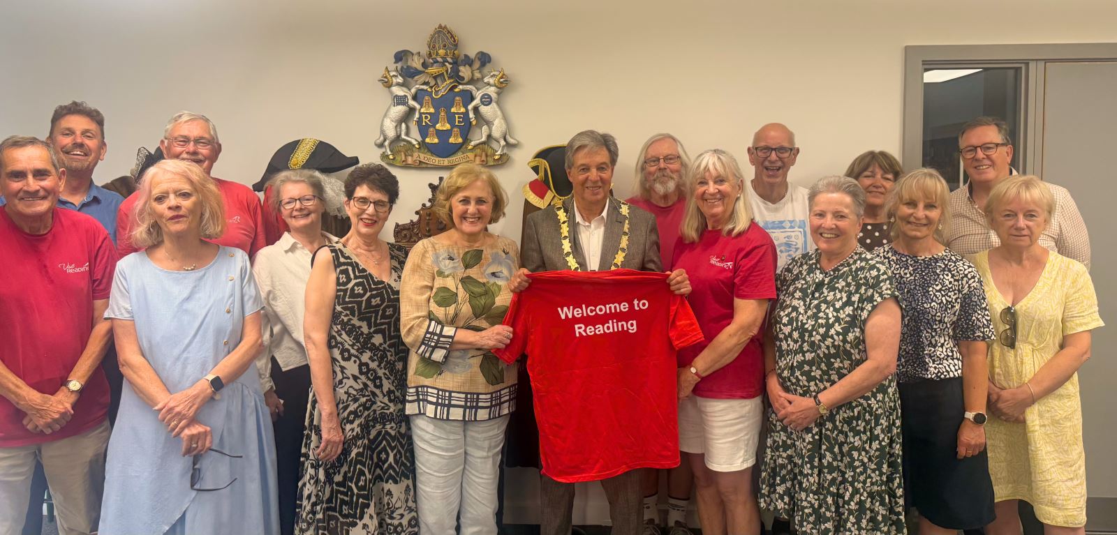 Mayor holding a 'Welcome to Reading' shirt with a large group of volunteers