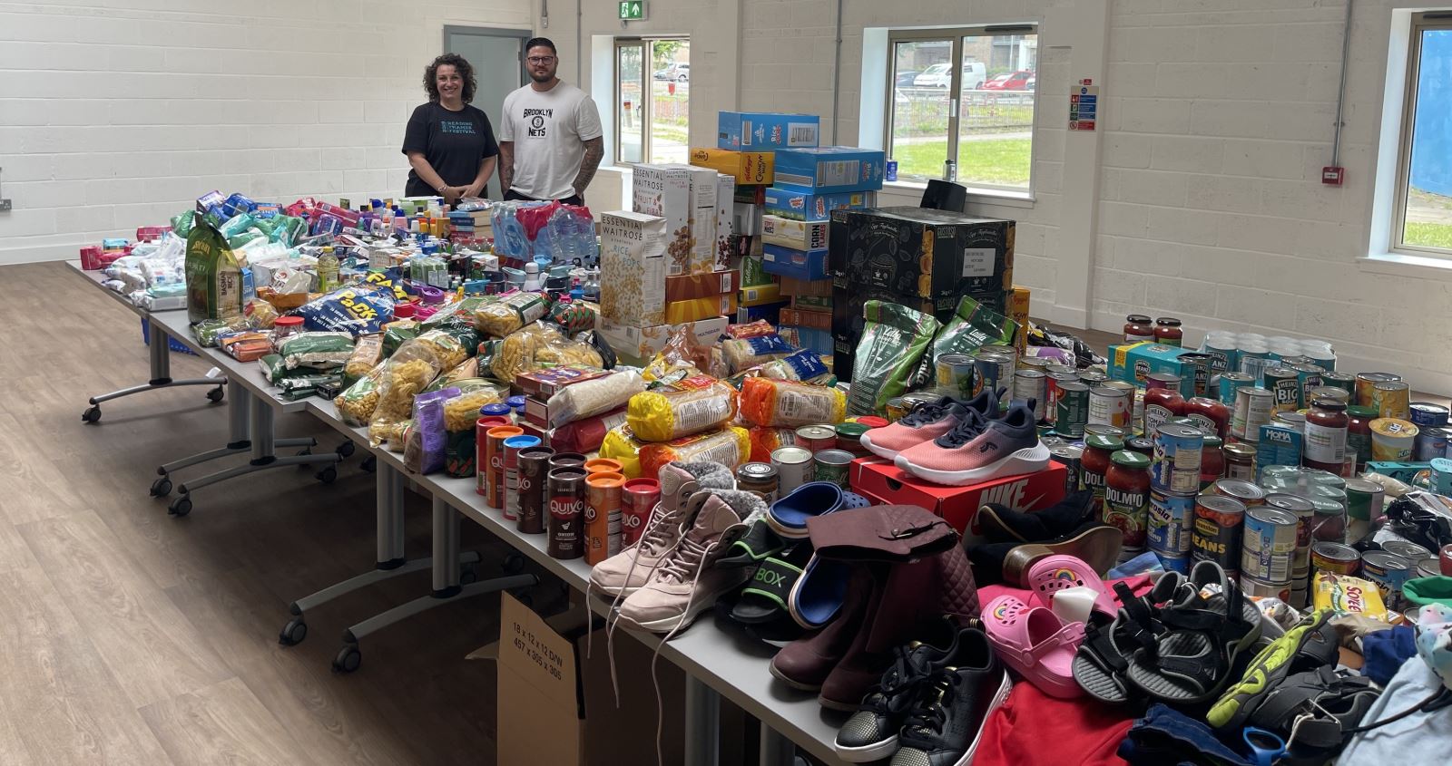 man and woman with large table of donations