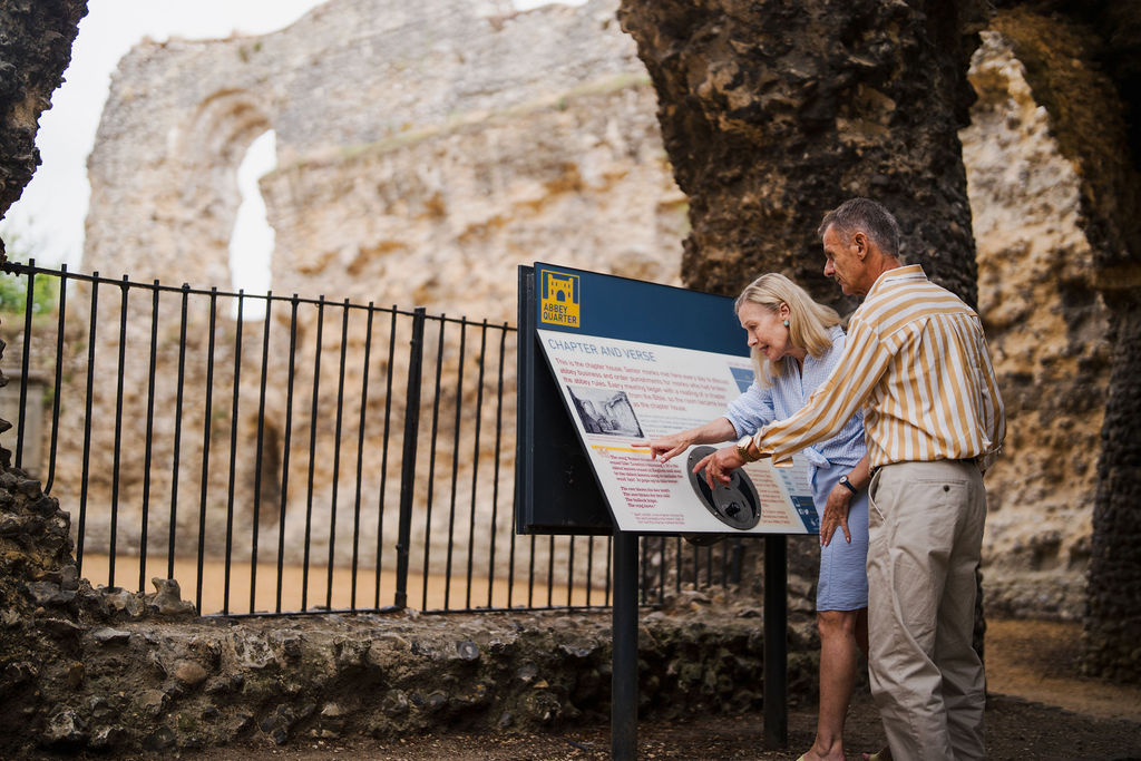 Couple looking at an information board at Reading Abbey Ruins