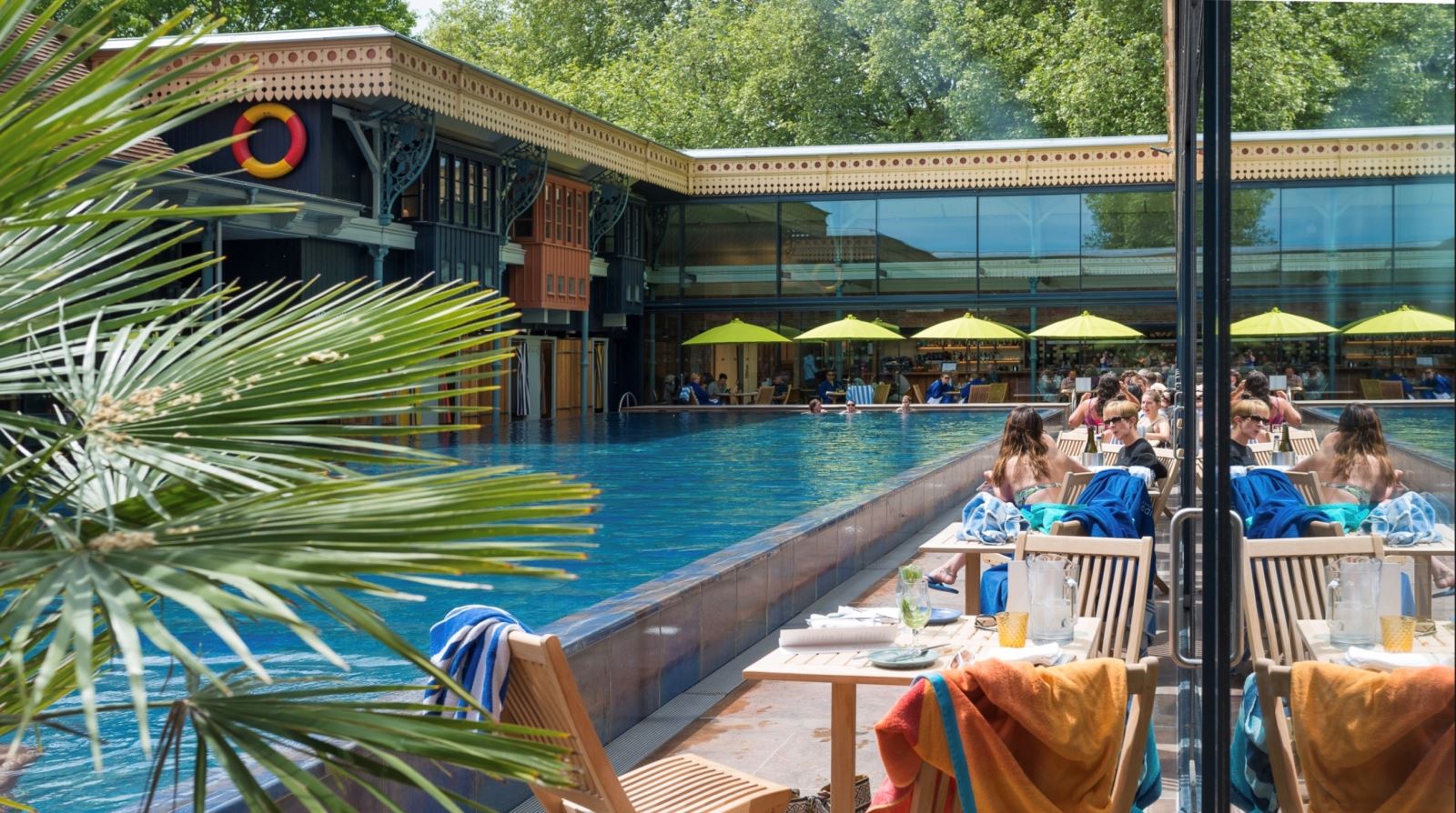 Tables and chairs along the edge of an outdoor pool