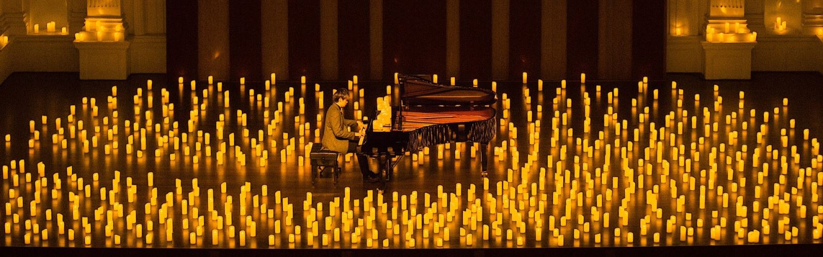 Candles surrounding piano player